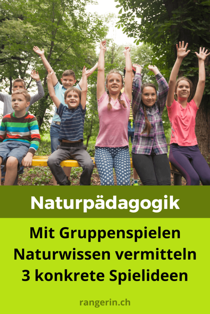 Kinder spielen ein Gruppenspiel, wo sie die Hände hochhalten. Dabei lernen sie spielerisch Wissen über die Natur.